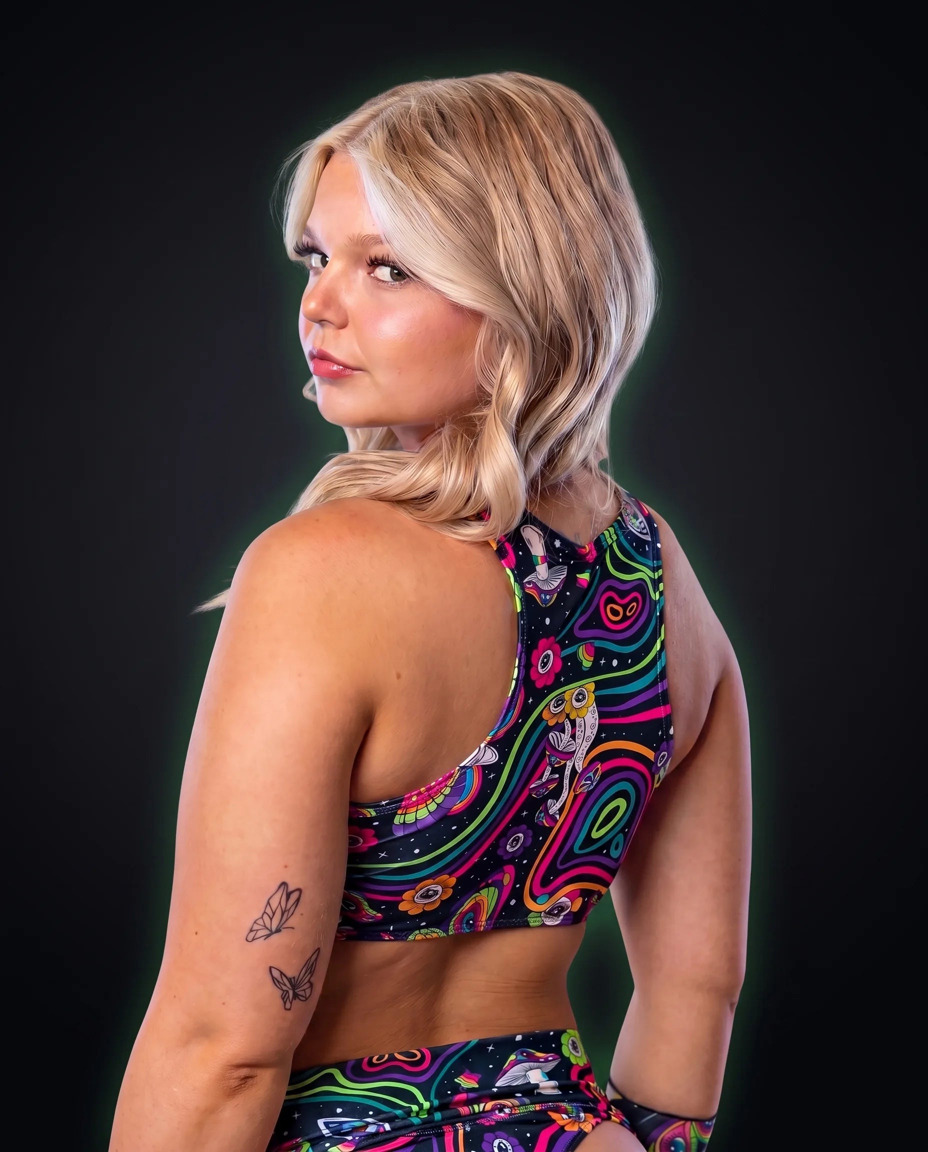 Back view of the Awaken Keyhole Top, a black racerback printed with rainbow psychedelic mushrooms and flowers